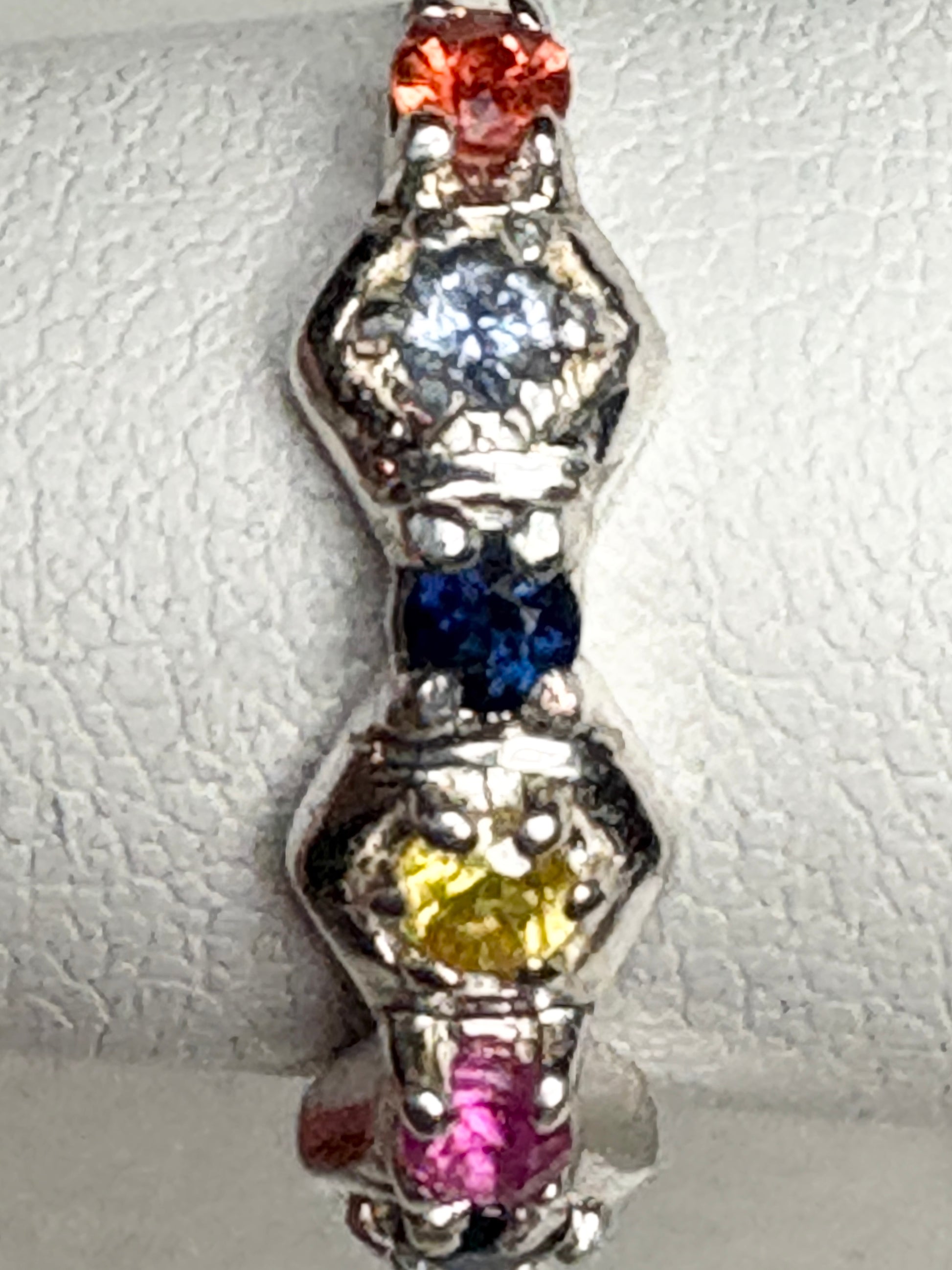 Sterling silver band ring with honeycomb shapes and colorful sapphires and ruby.