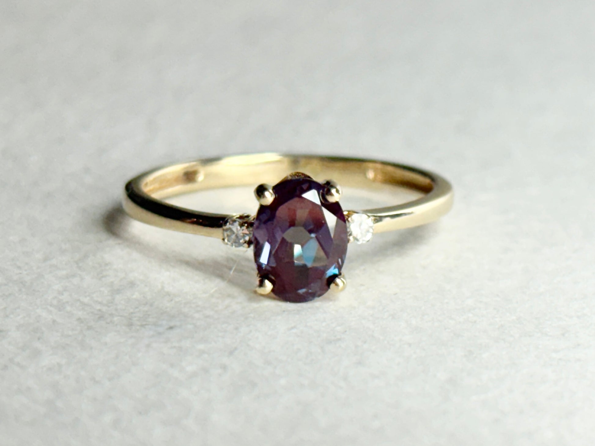Oval lab grown alexandrite and diamond ring in 10k gold.