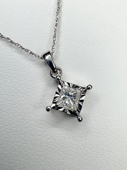 A princess cut diamond pendant necklace on a thin white gold chain.