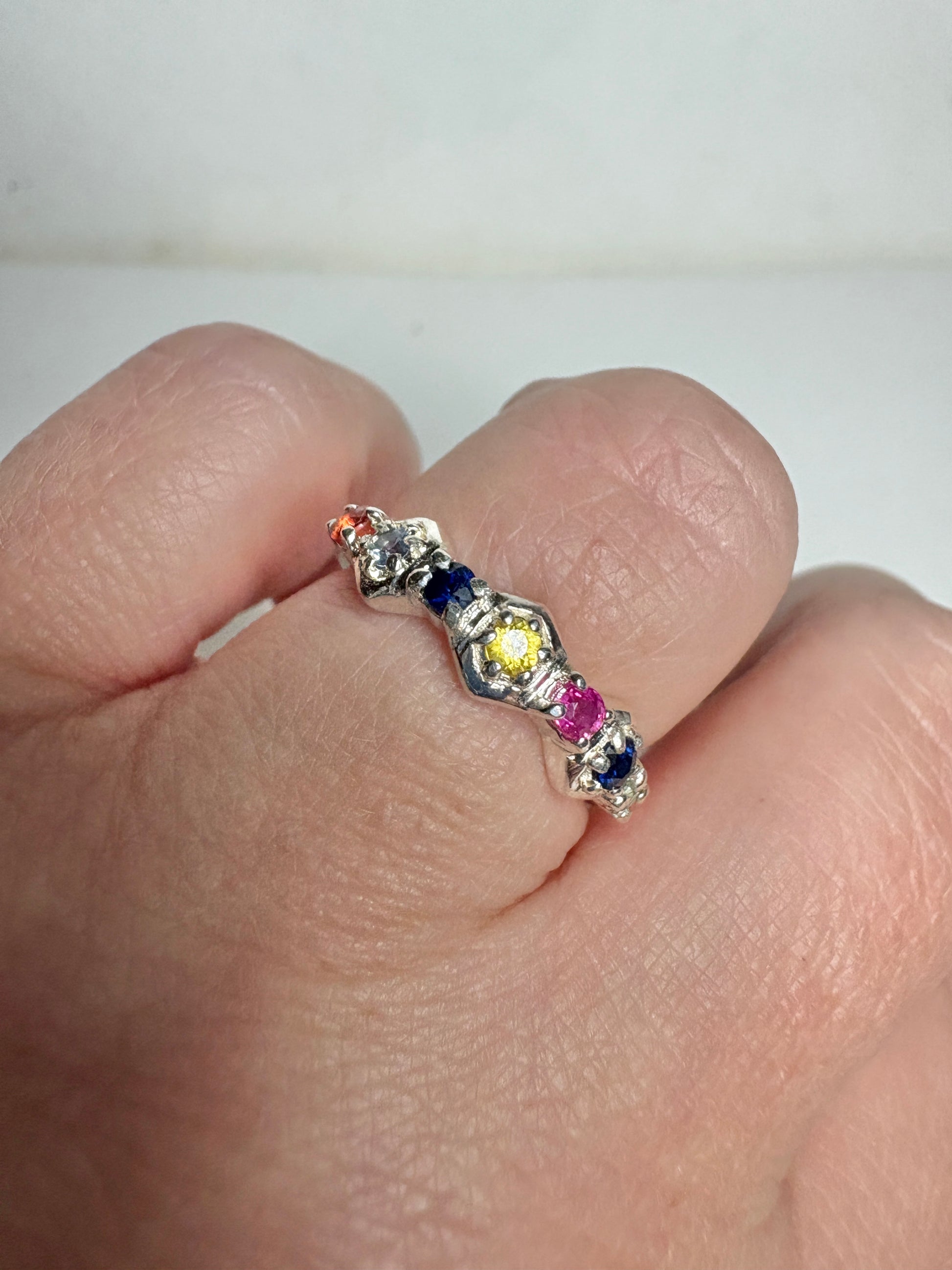 Sterling silver band ring with multi-colored sapphires and ruby in honeycomb shapes.
