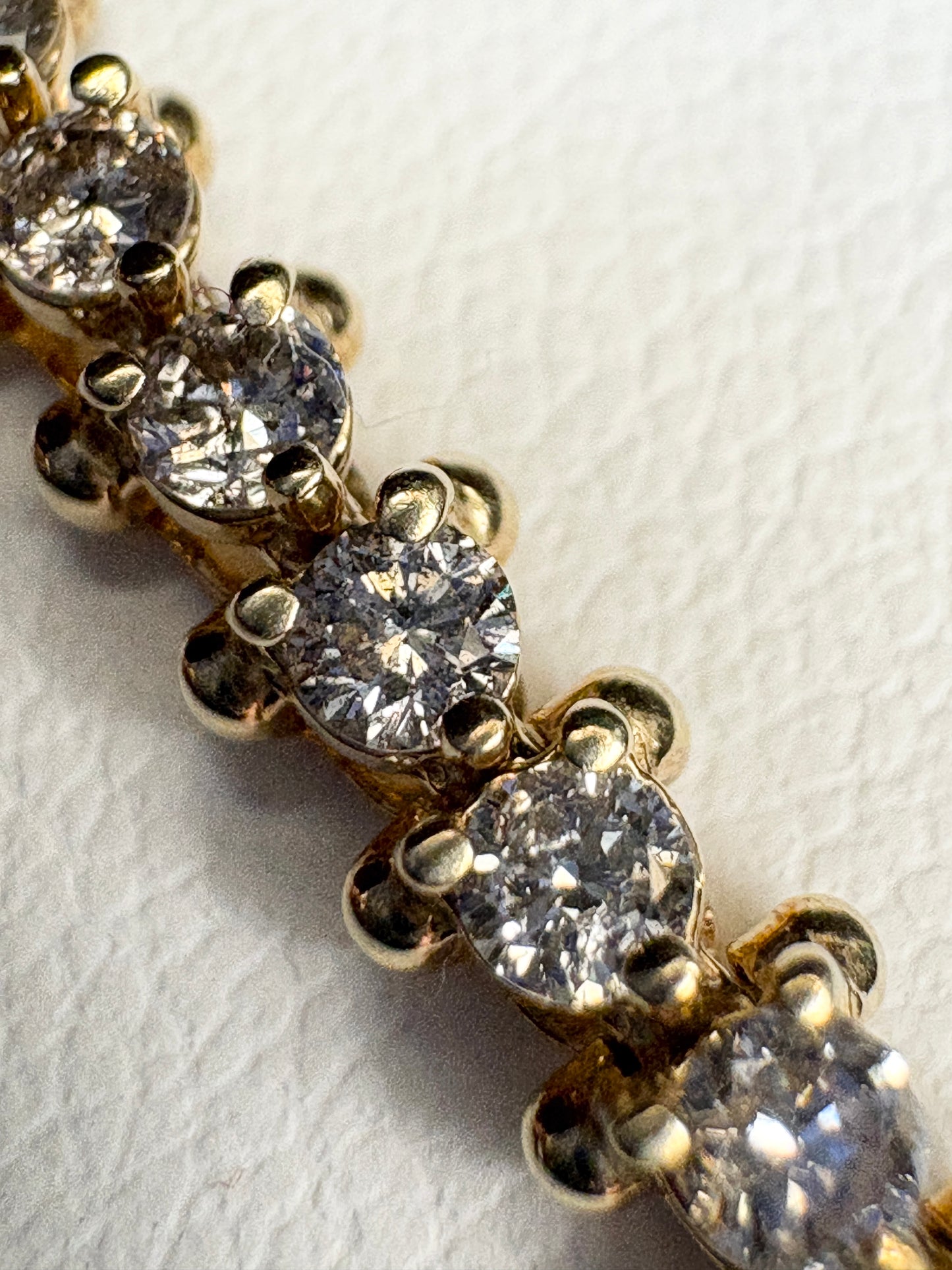 Diamond tennis bracelet with 57 round diamonds in solid 14k gold.