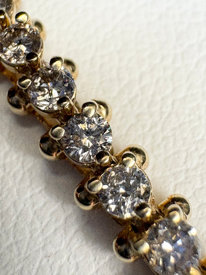 Diamond tennis bracelet with 57 round diamonds in solid 14k gold.