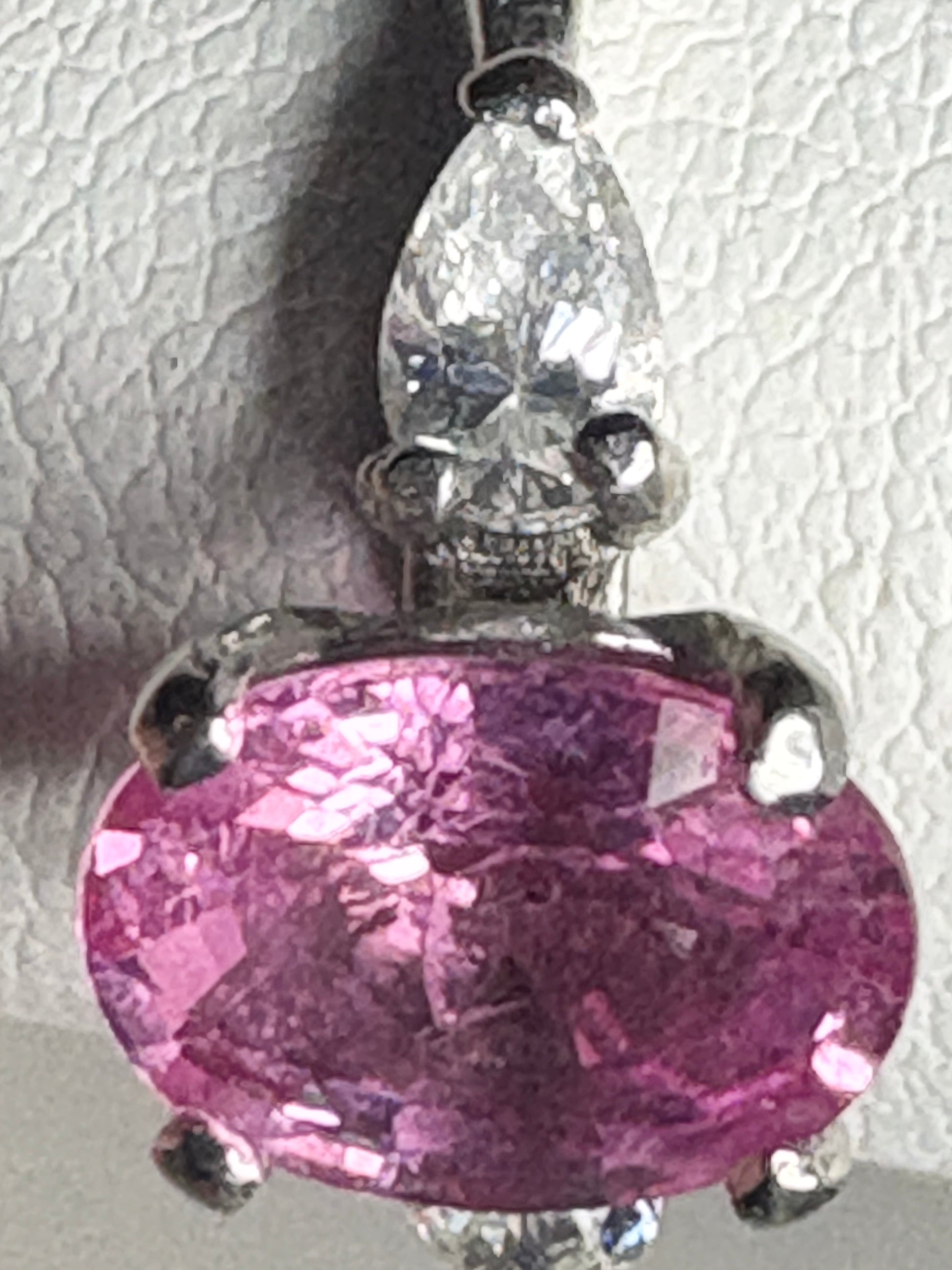 Platinum ring with pink sapphire and pear-shaped diamond.