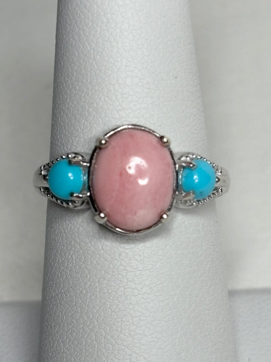 Sterling silver ring with oval peach opal and two round turquoise cabochons.