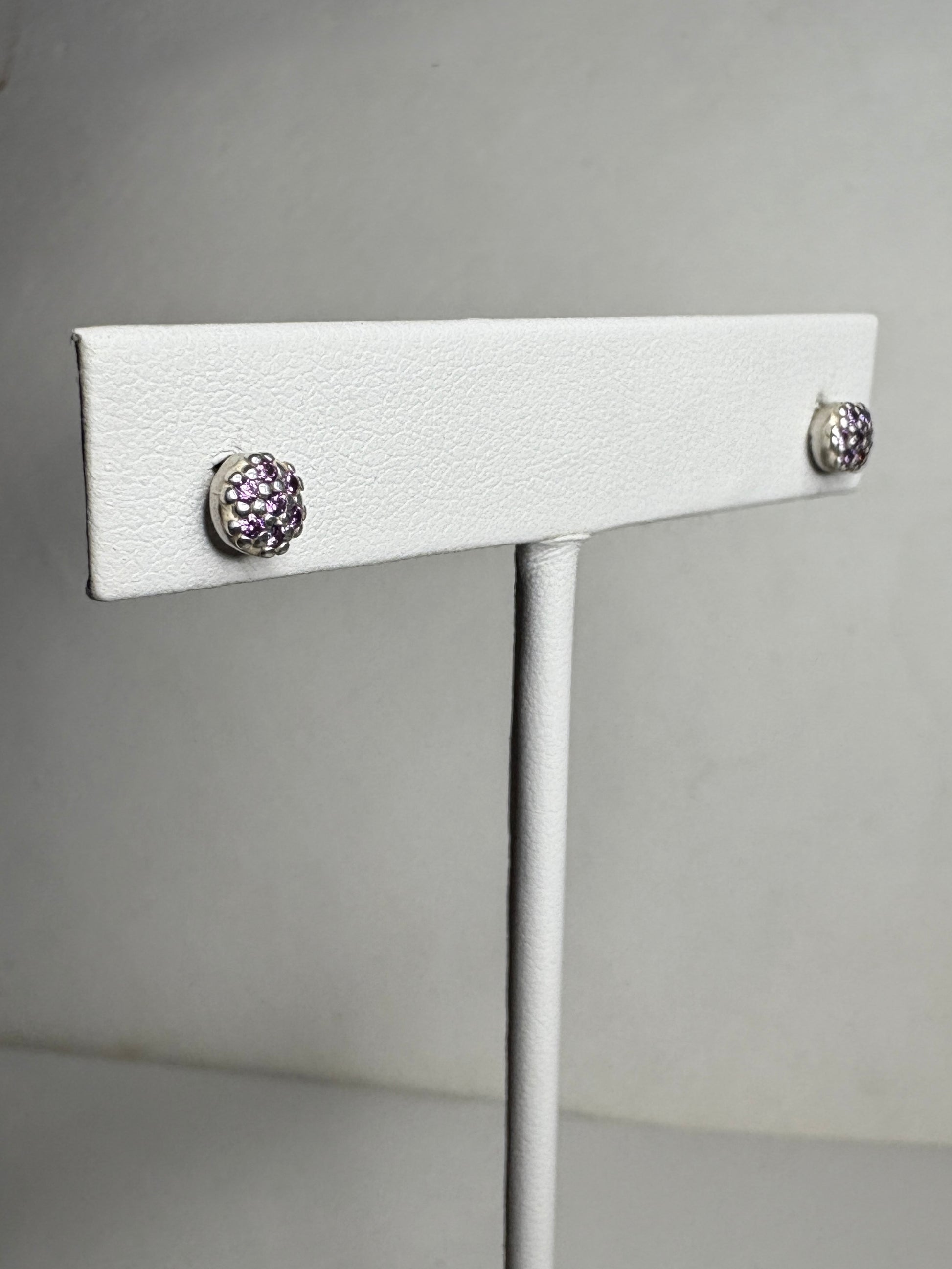 Sterling silver stud earrings with pave-set violet purple cubic zirconia stones.