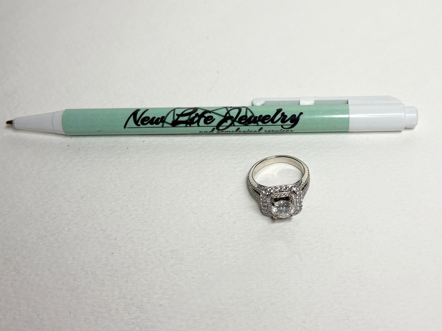 A 14k white gold ring with a double halo of natural diamonds and a 7mm moissanite center stone.