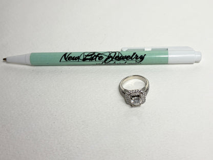 A 14k white gold ring with a double halo of natural diamonds and a 7mm moissanite center stone.