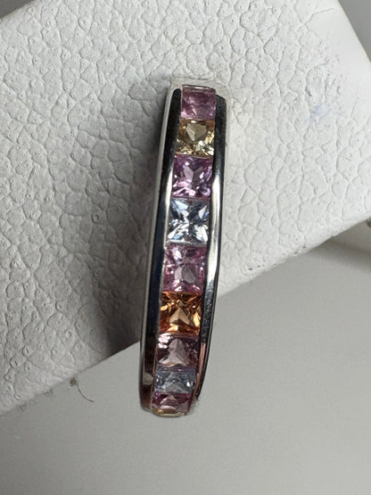 Sterling silver huggie hoop earrings with channel-set princess-cut multi-color sapphires.