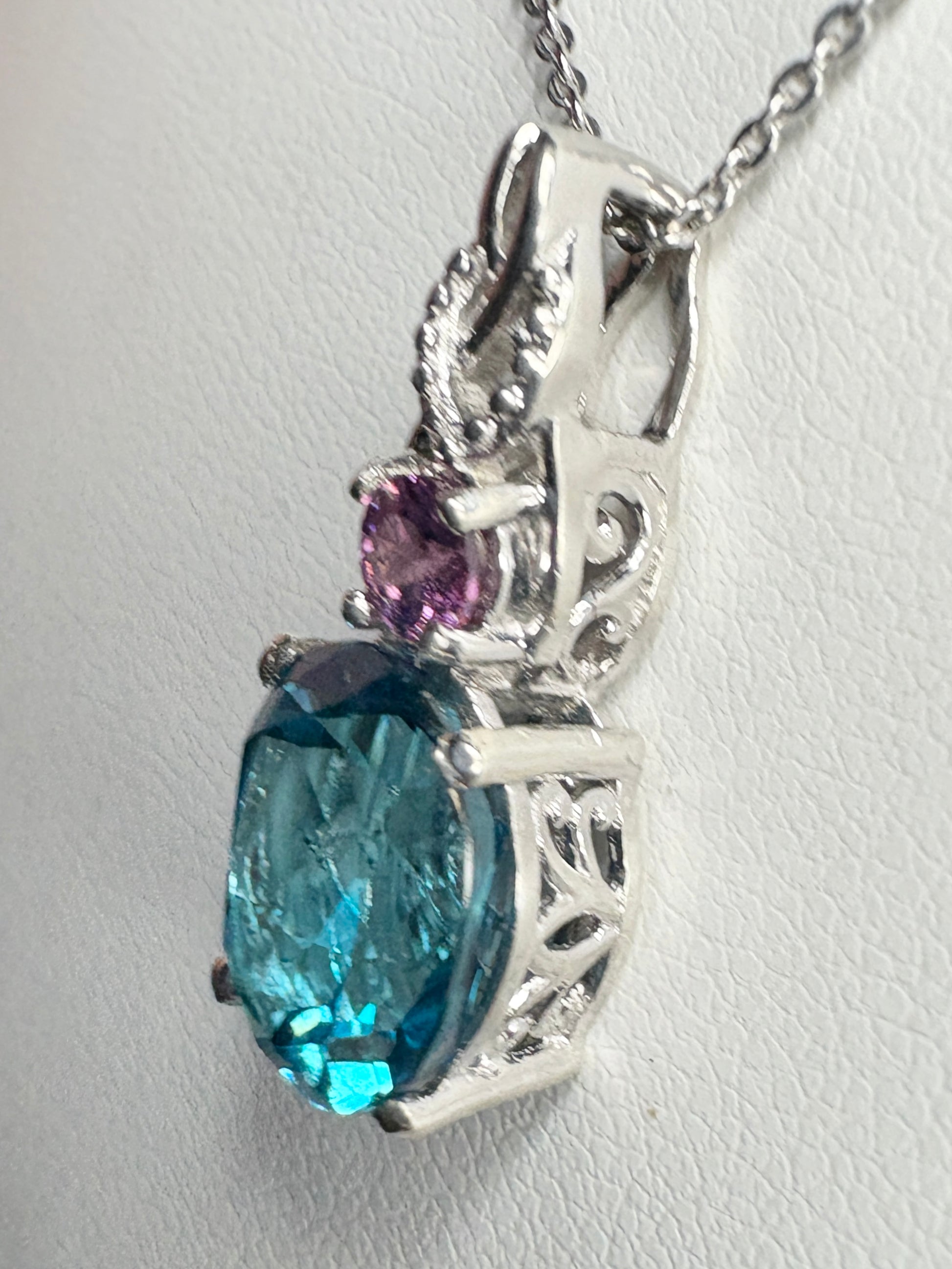Sterling silver pendant necklace with oval London blue topaz and round rhodolite garnet.