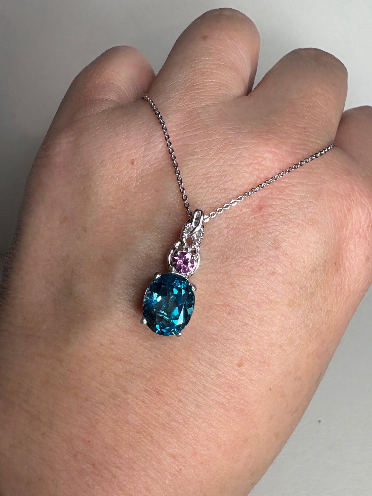 Sterling silver pendant necklace with oval London blue topaz and rhodolite garnet.