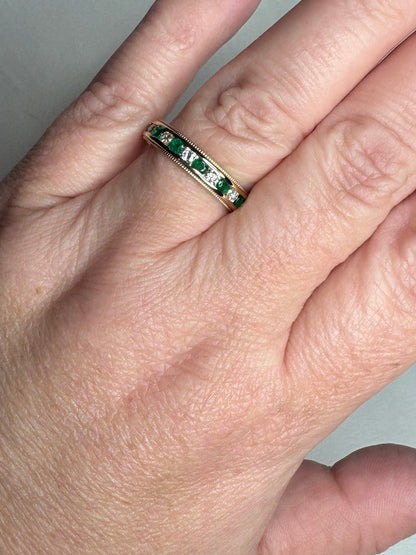 18k gold band ring with alternating emeralds and diamonds.