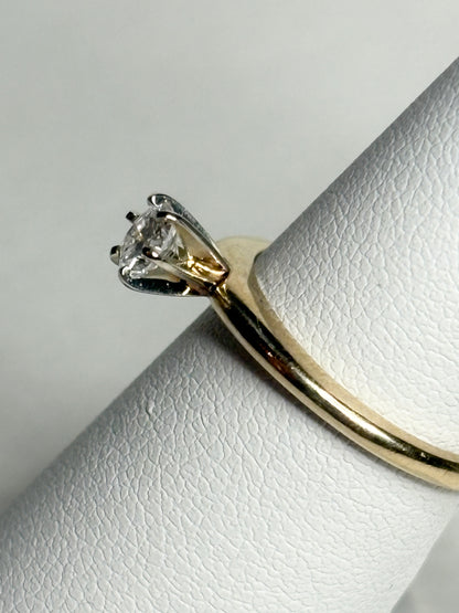 A 14k gold ring with a single diamond set in white gold prongs.