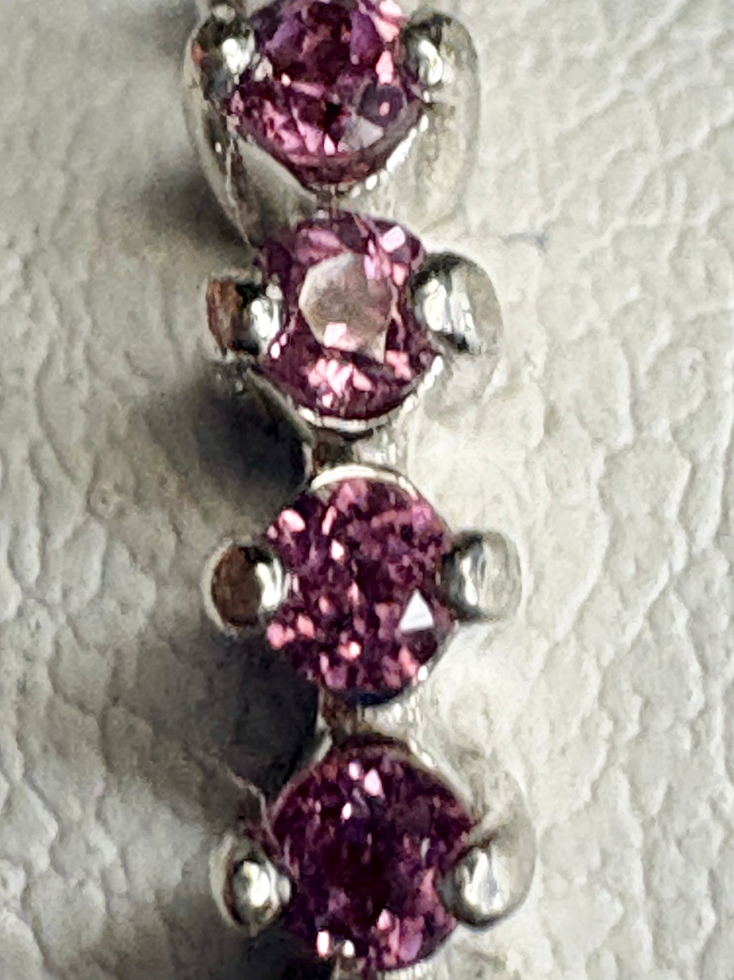 Sterling silver band ring with four round rhodolite garnets.