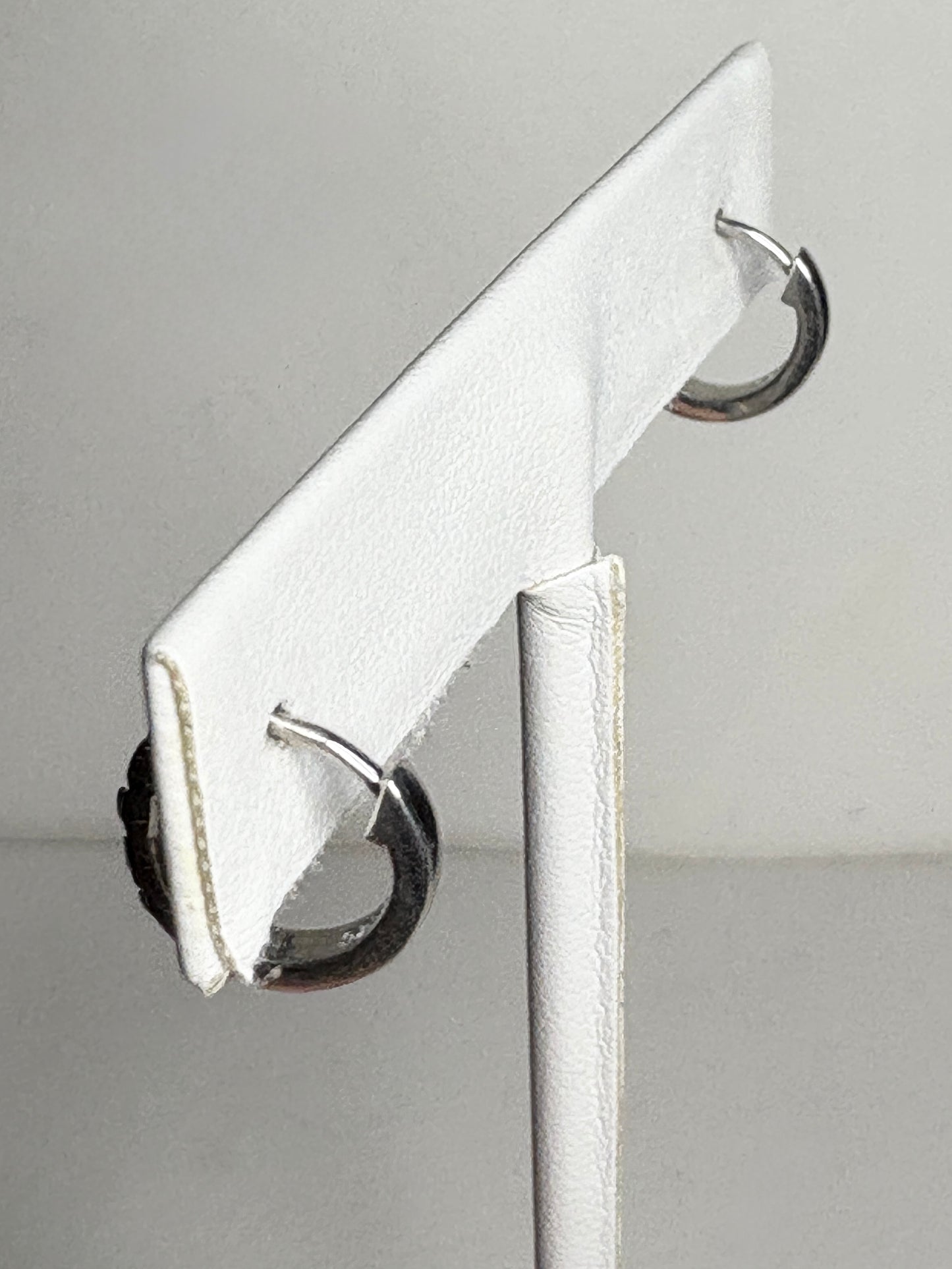 Small sterling silver huggie hoop earrings with rhodolite garnets.