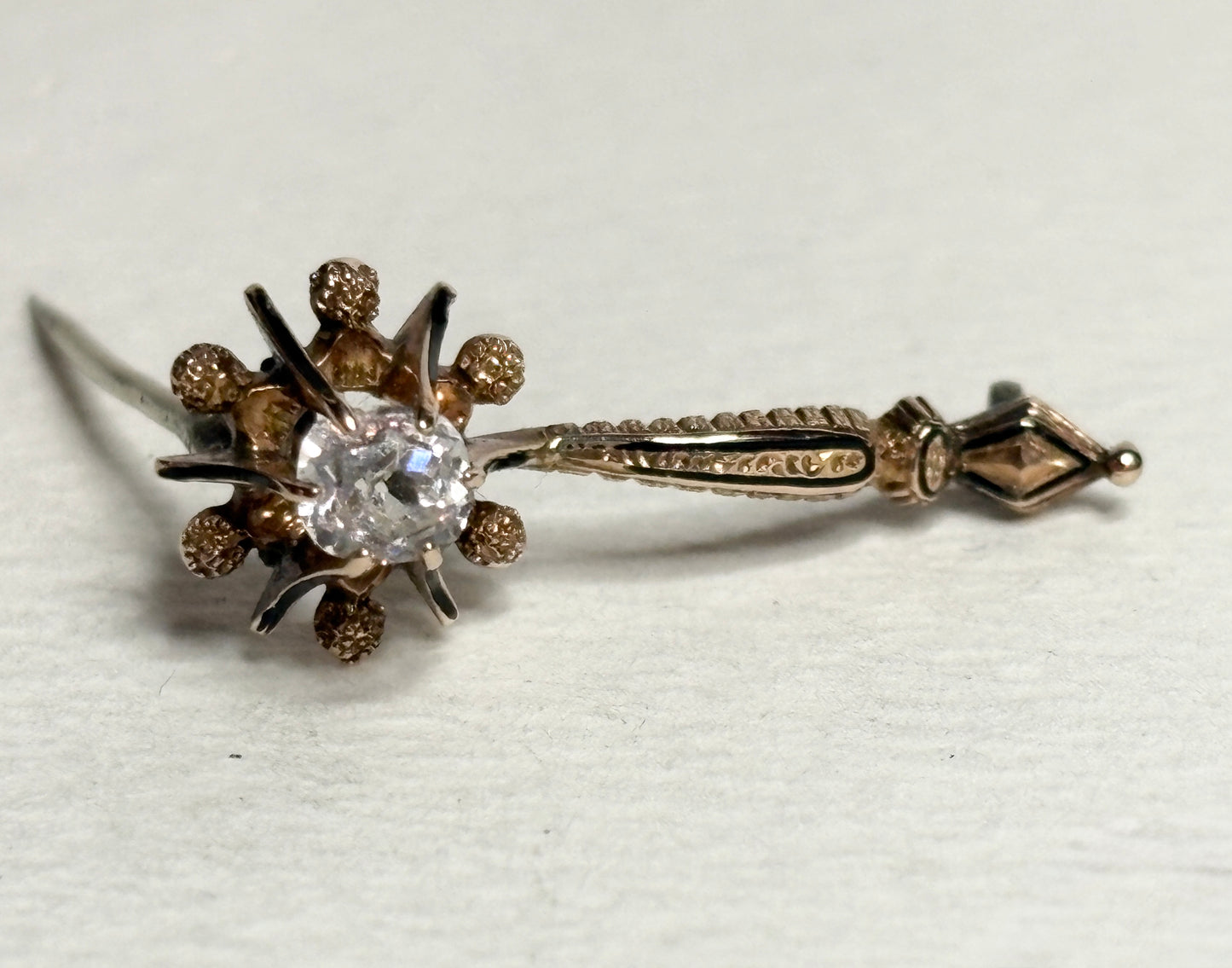 Antique 14k gold brooch with a central paste gem and enamel detailing.