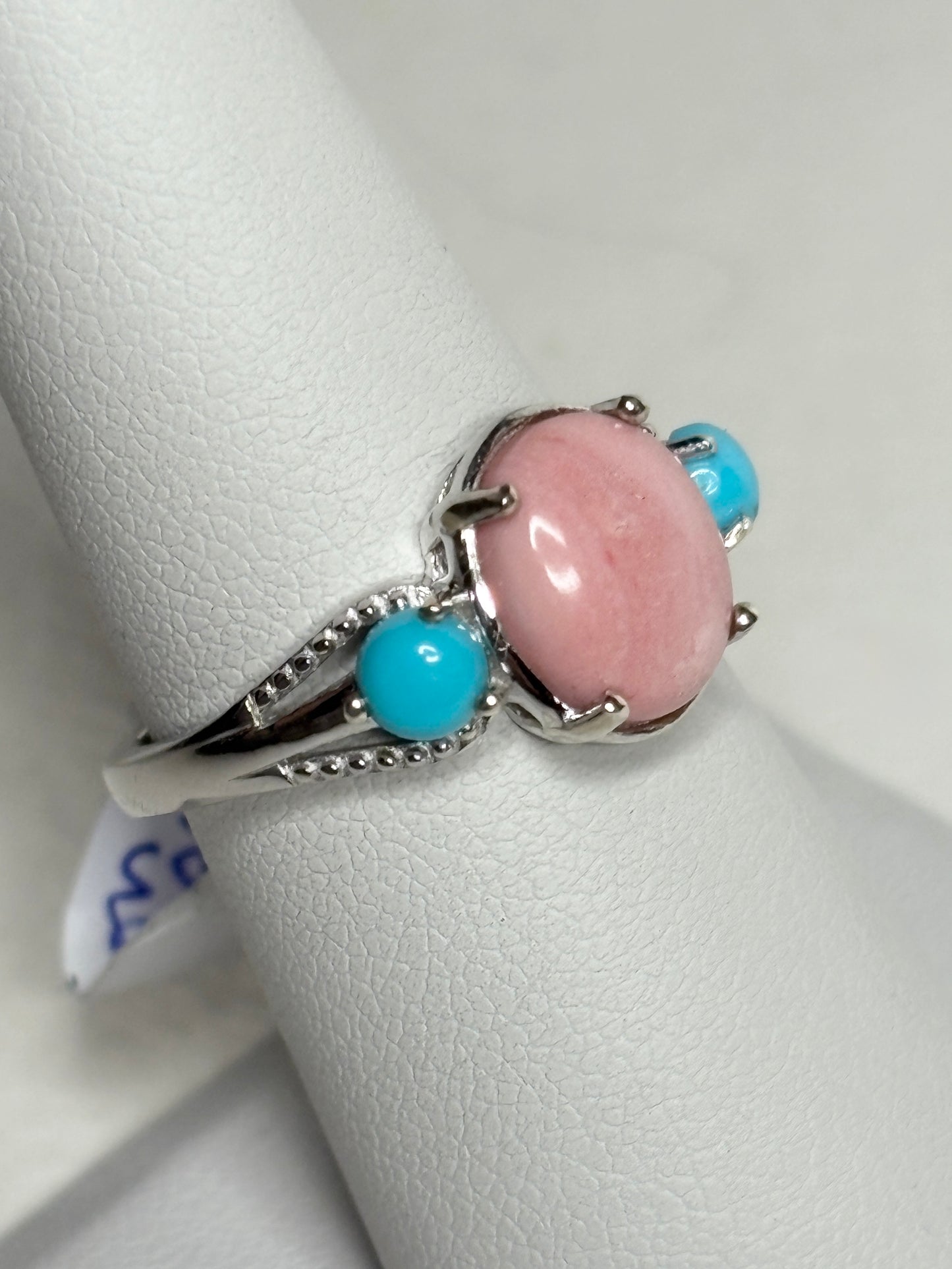 Sterling silver ring with oval peach opal and two round turquoise stones.