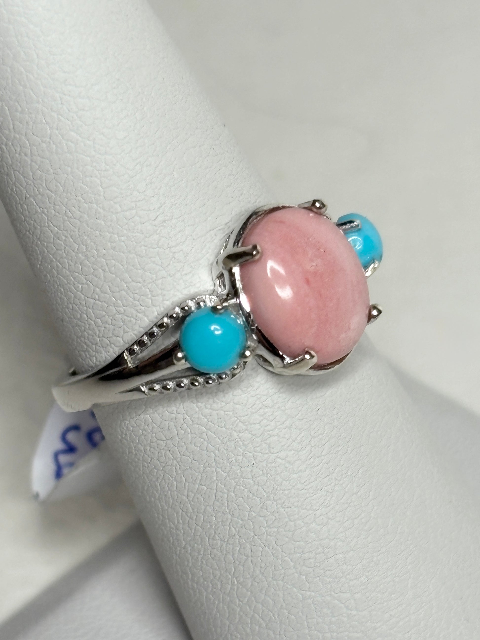 Sterling silver ring with oval peach opal and two round turquoise stones.