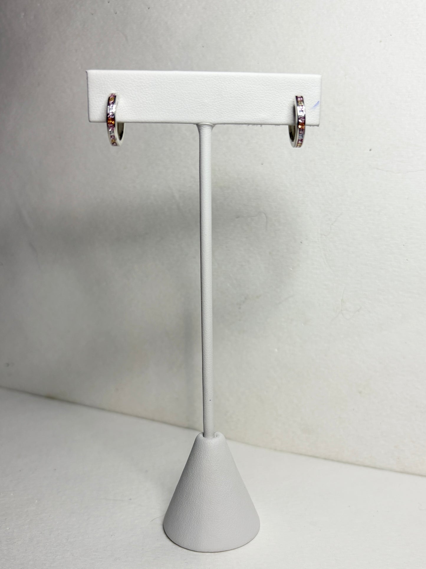 Sterling silver huggie hoop earrings with princess-cut multi-color sapphires.