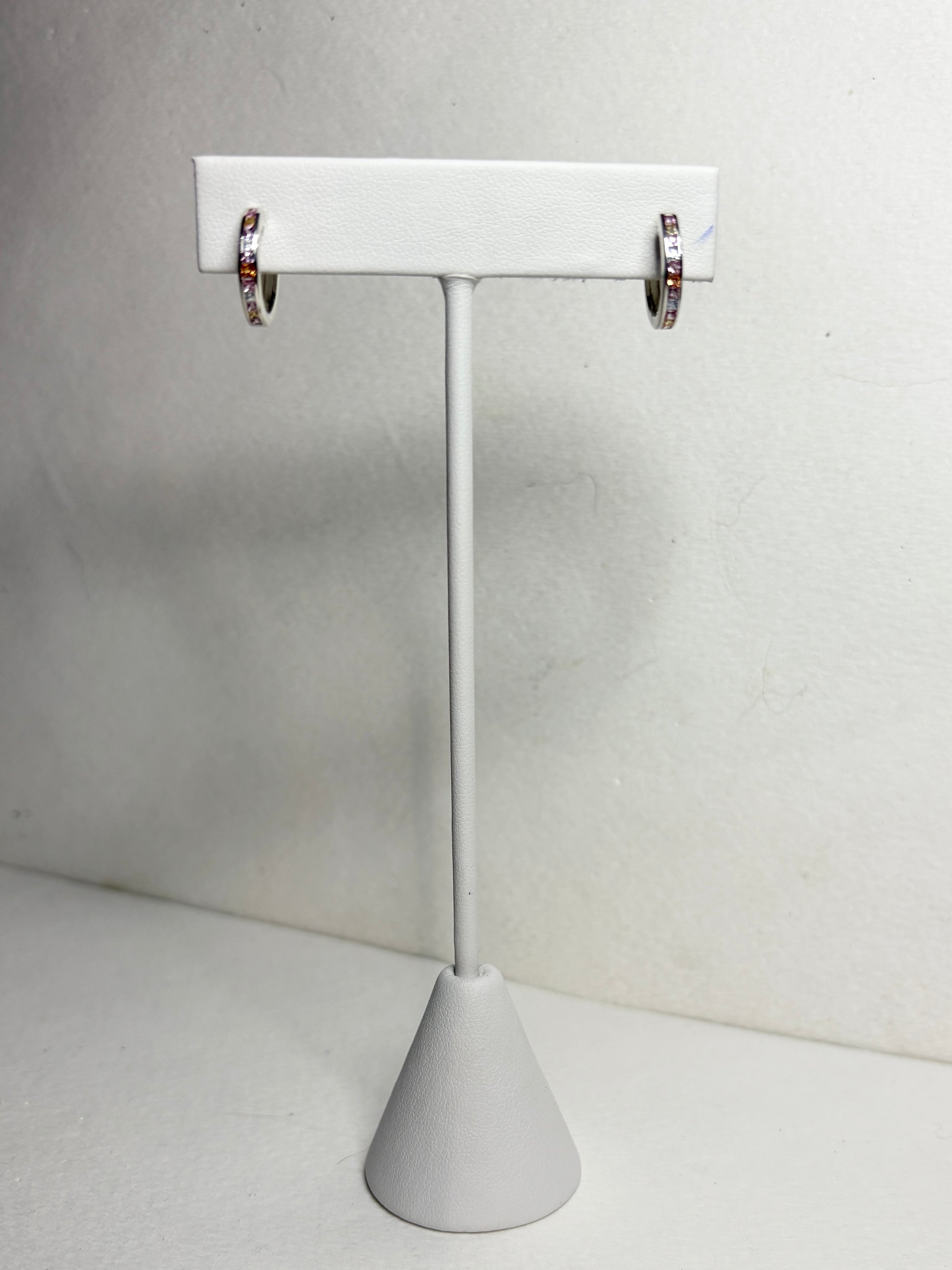 Sterling silver huggie hoop earrings with princess-cut multi-color sapphires.