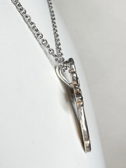 Ornate Black Hills Gold cross pendant with green and rose gold leaves on a yellow gold base.