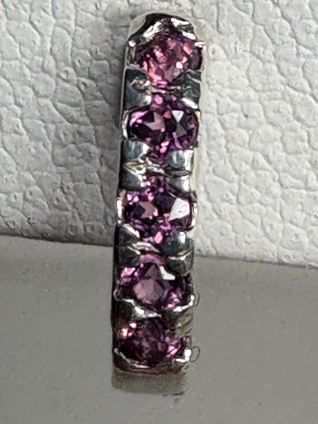 Sterling silver huggie hoop earrings with small rhodolite garnets.