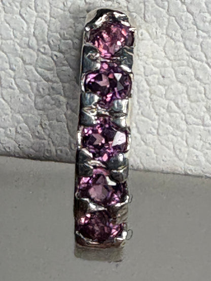 Sterling silver huggie hoop earrings with small rhodolite garnets.