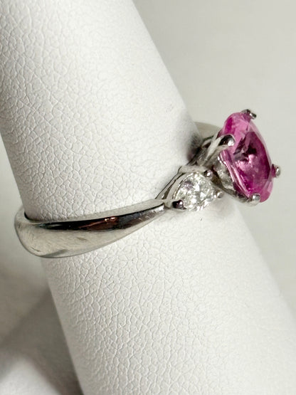 Platinum ring with a pink sapphire and two pear-shaped diamonds.
