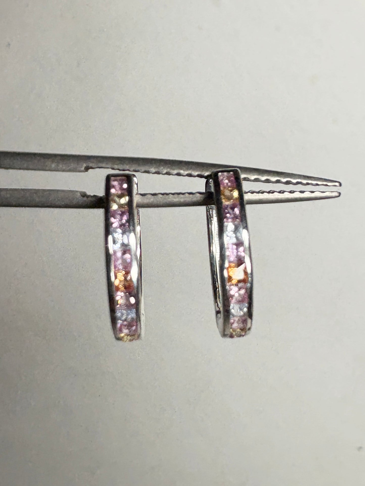 Sterling silver huggie hoop earrings with princess-cut multi-color sapphires.