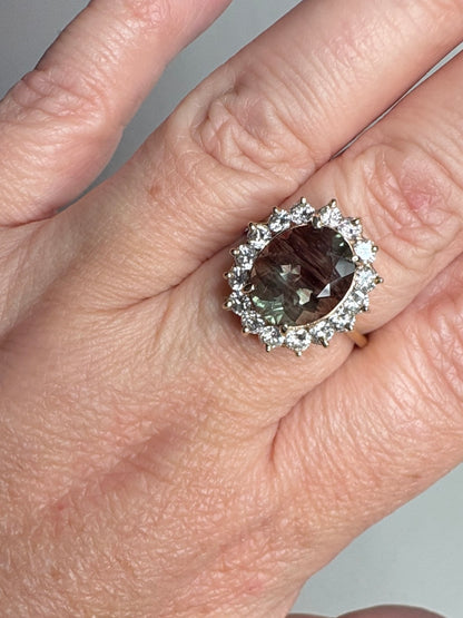Large oval dichroic Oregon sunstone ring with diamond halo in 14k gold.