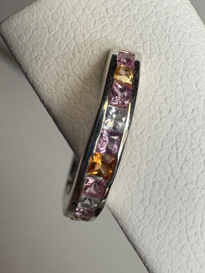 Sterling silver huggie hoop earrings with channel-set multi-color princess-cut sapphires.