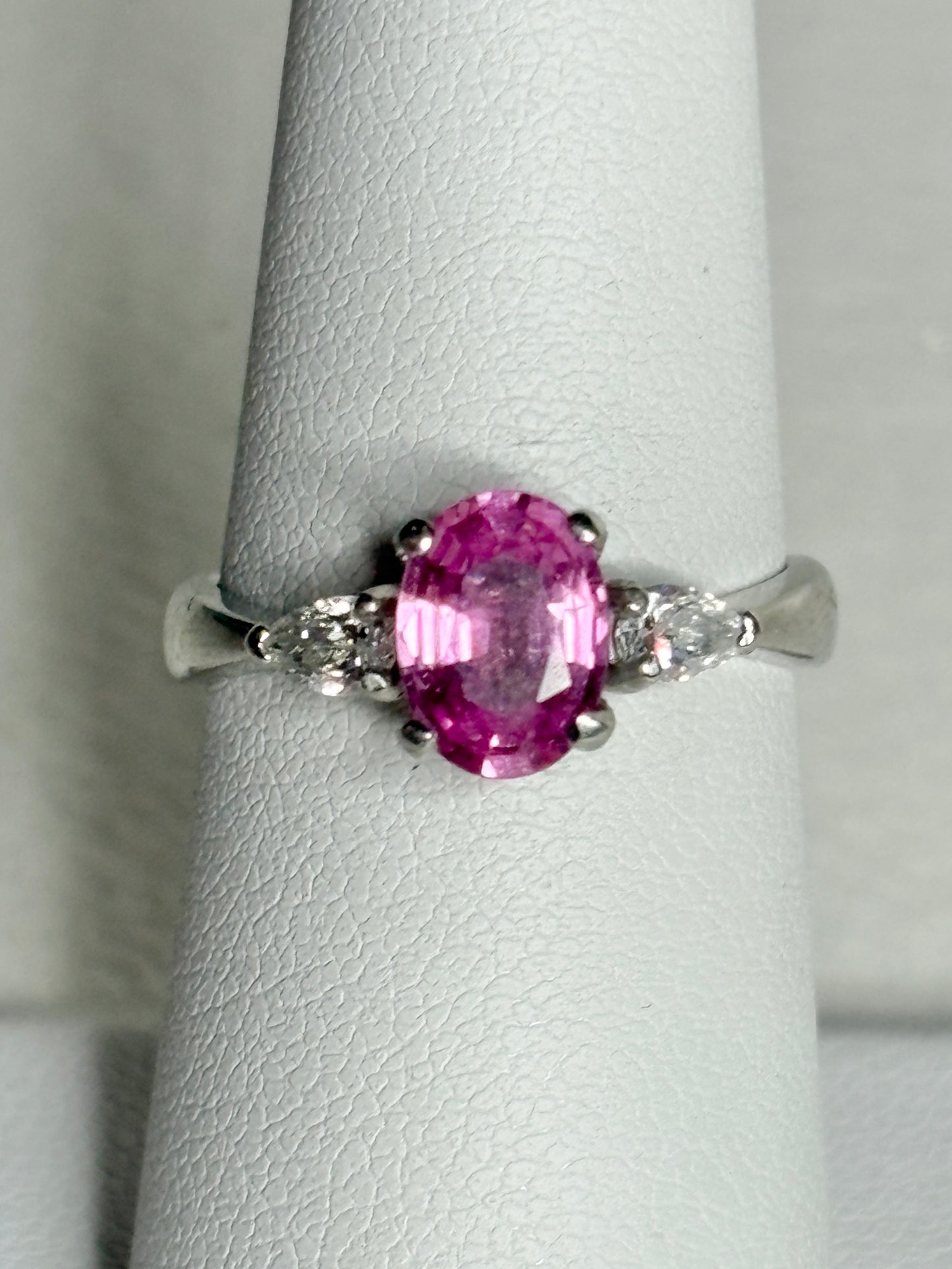Platinum ring with pink sapphire and pear-shaped diamonds.