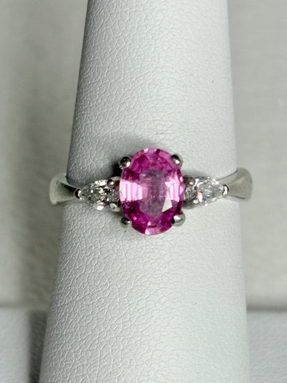 Platinum ring with pink sapphire and pear-shaped diamonds.