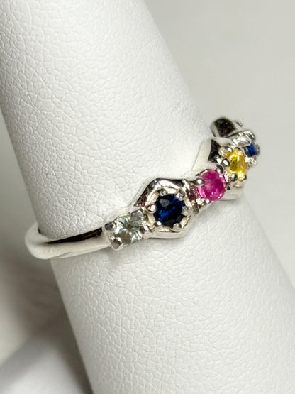 Sterling silver band ring with honeycomb shapes and multi-colored sapphires and ruby.