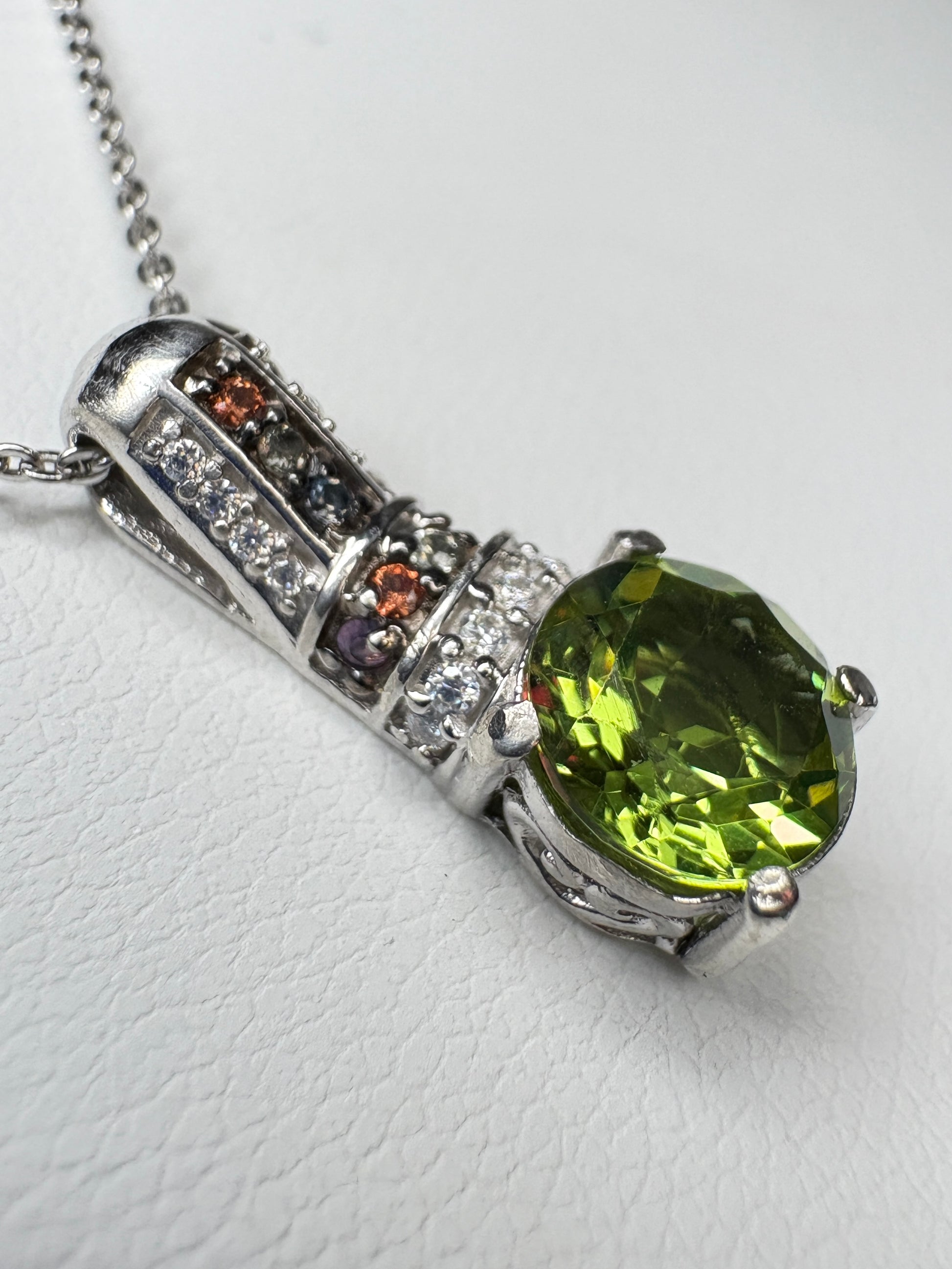 Sterling silver pendant necklace with a color-changing glass stone, moissanite, and multi-colored sapphires.