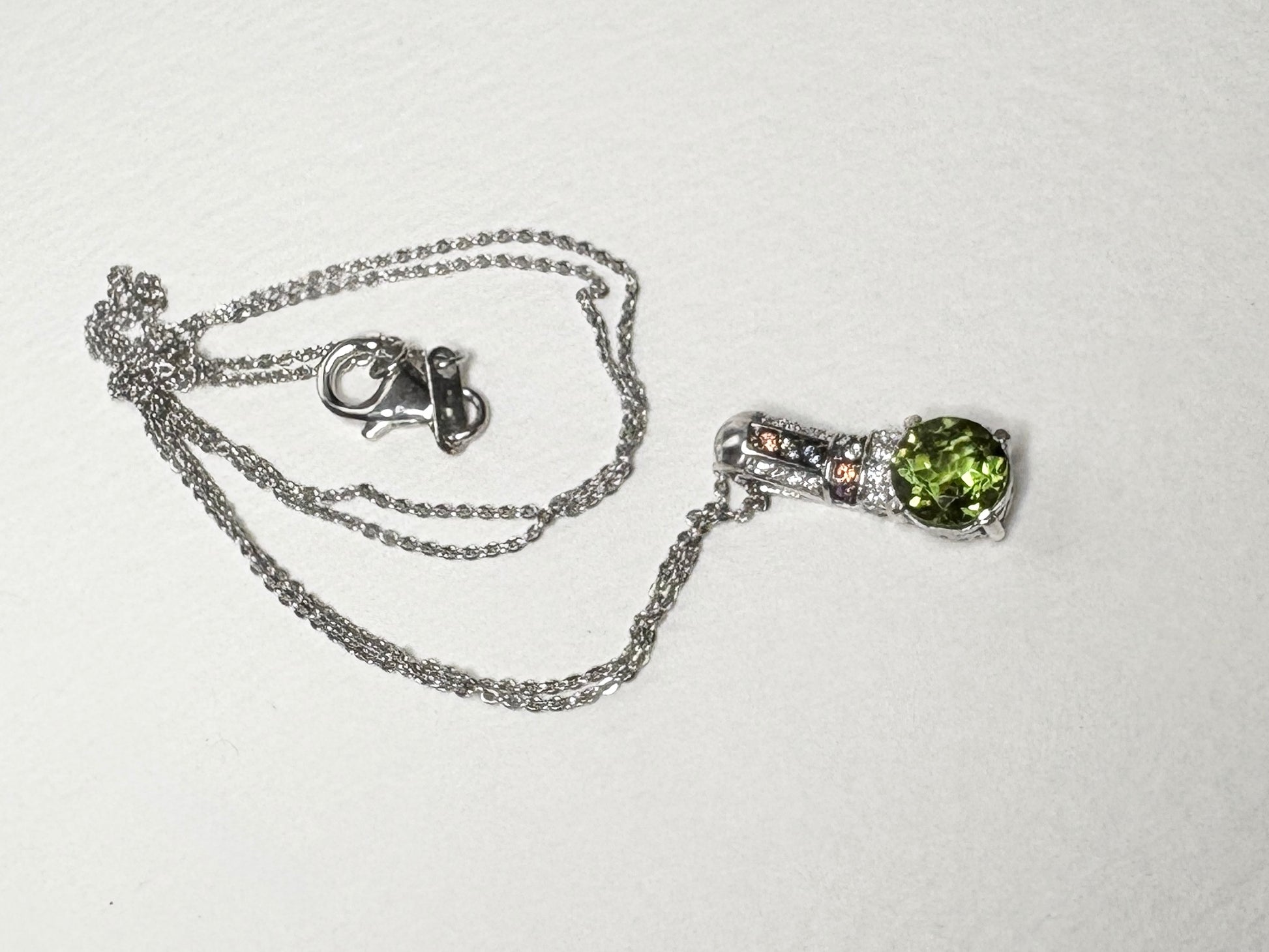 Sterling silver necklace with a green color-change glass pendant and multi-color sapphires.