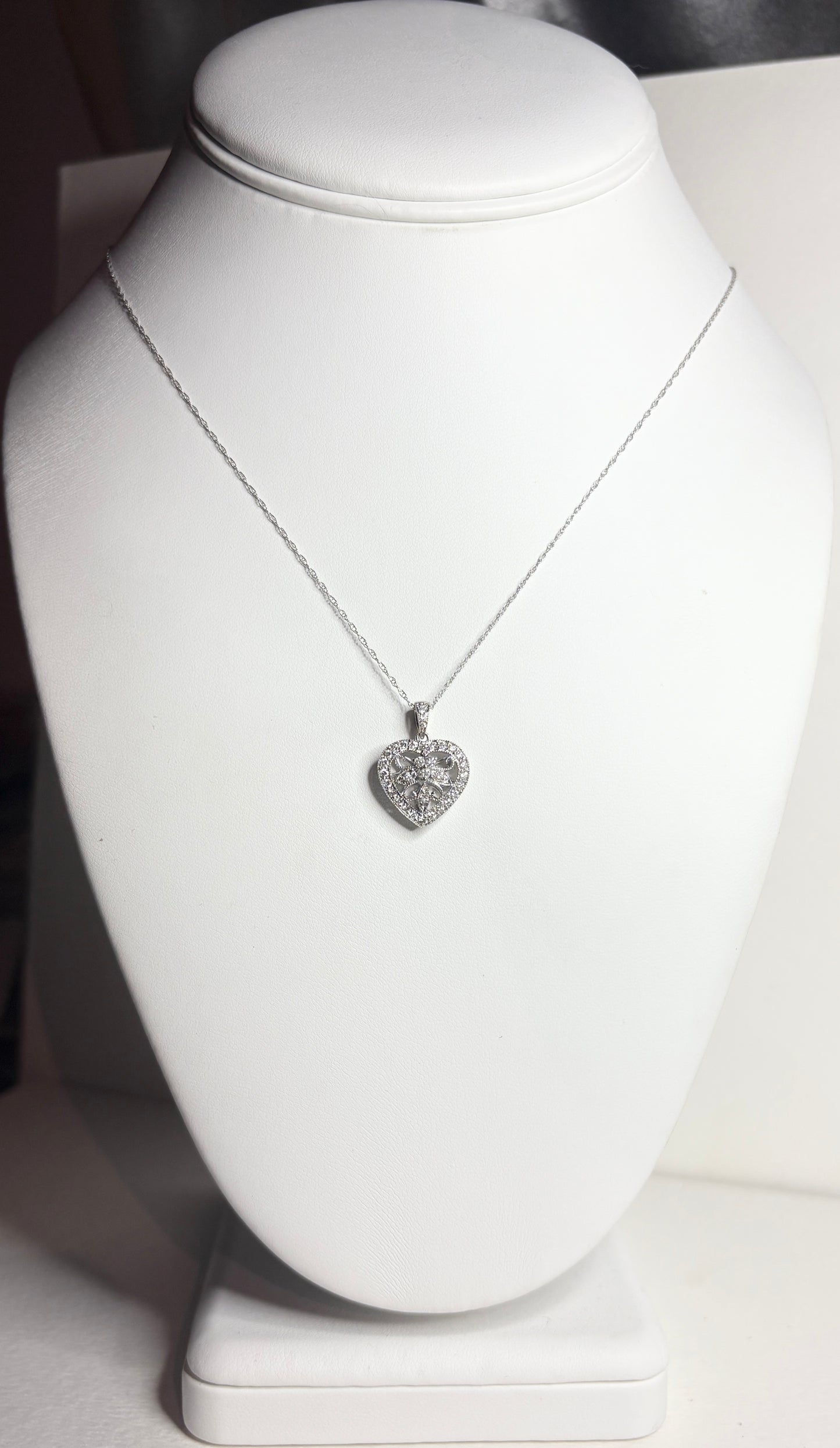 A white gold heart pendant necklace with diamonds.