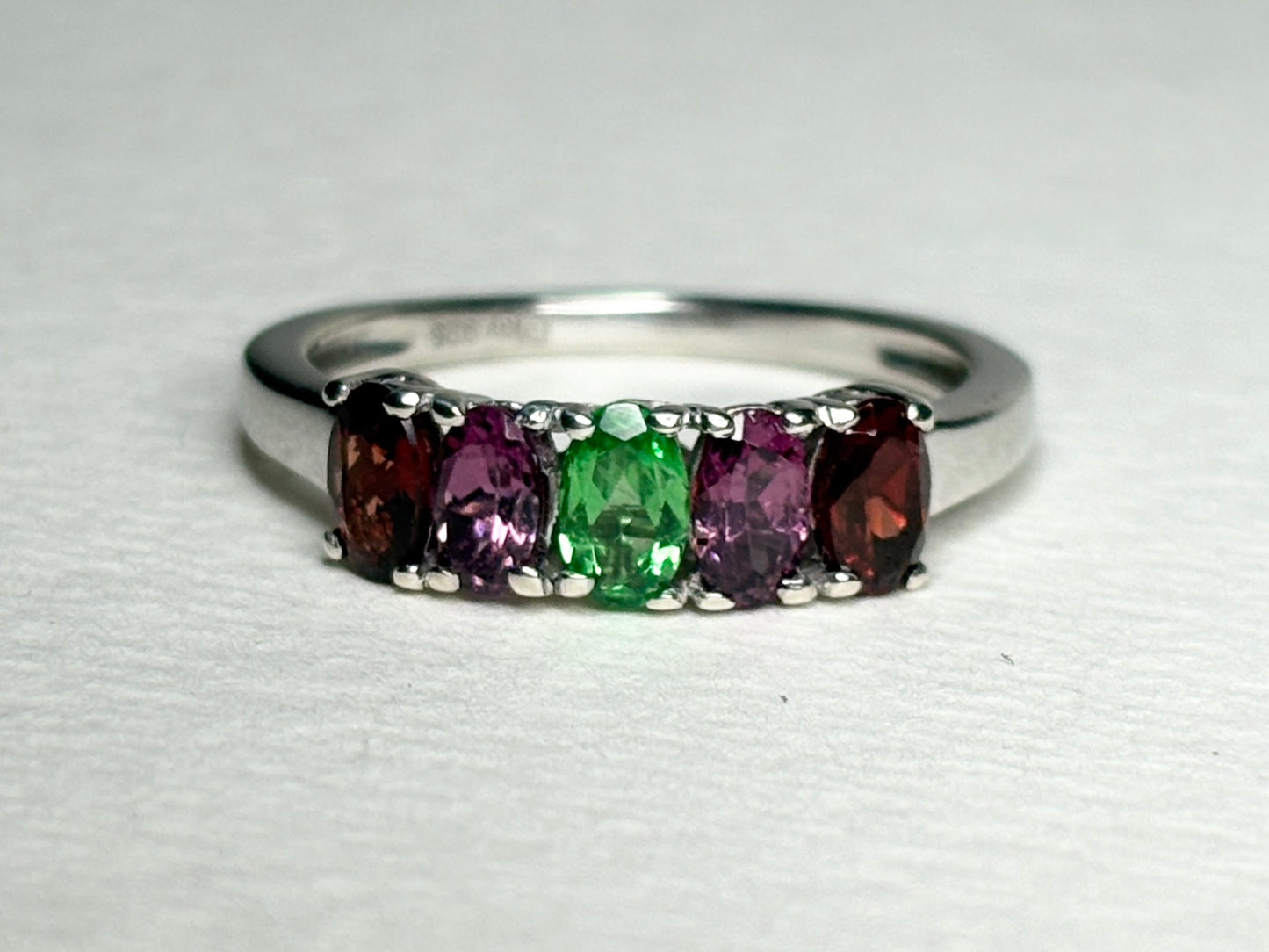 Sterling silver ring with five oval garnets: almandine, rhodolite, and tsavorite.