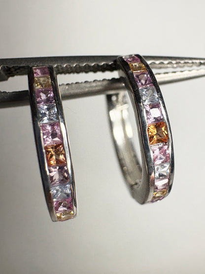Sterling silver huggie hoop earrings with princess-cut multi-color sapphires.