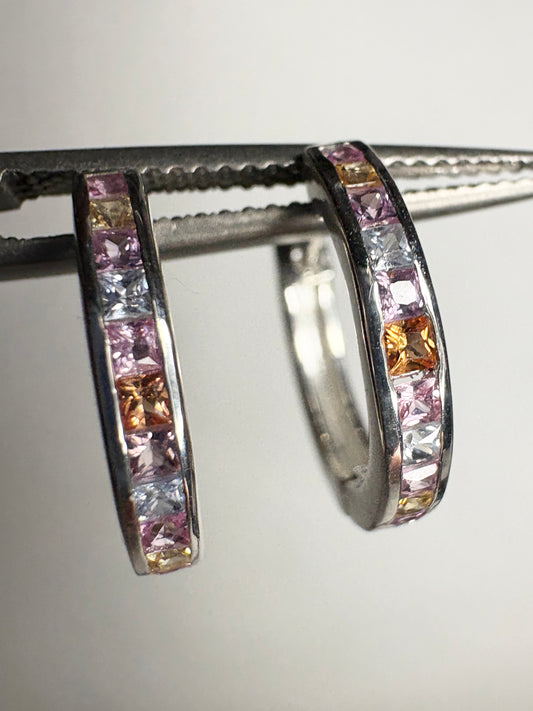 Sterling silver huggie hoop earrings with princess-cut multi-color sapphires.