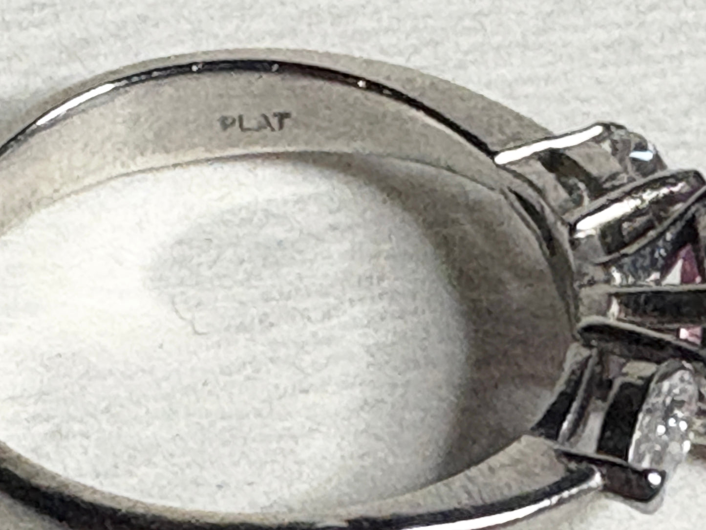 Platinum ring with pink sapphire and pear-shaped diamonds.