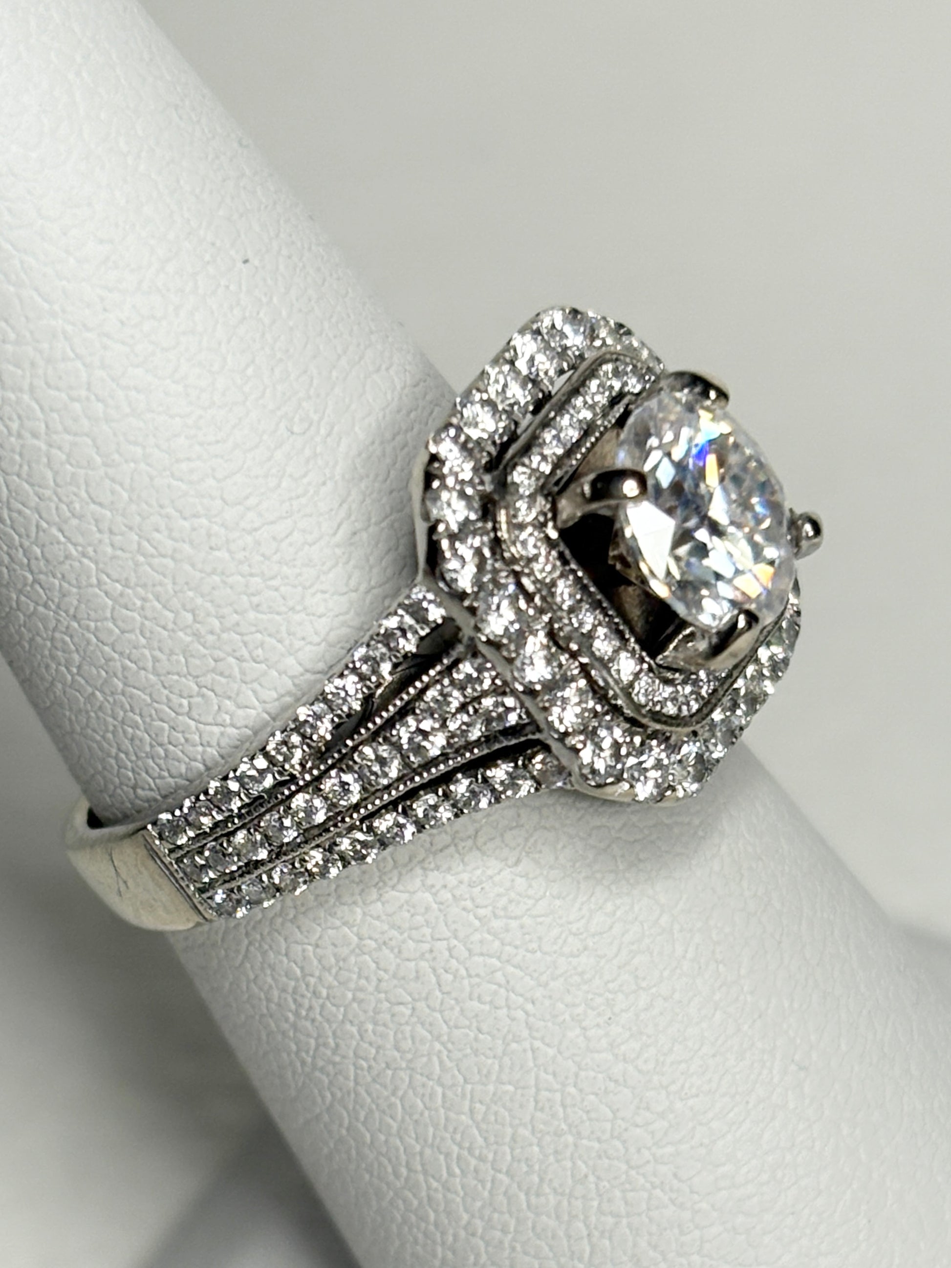 A 14k white gold ring with a double halo of natural diamonds and a moissanite center stone.