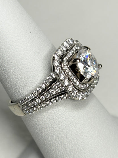 A 14k white gold ring with a double halo of natural diamonds and a moissanite center stone.