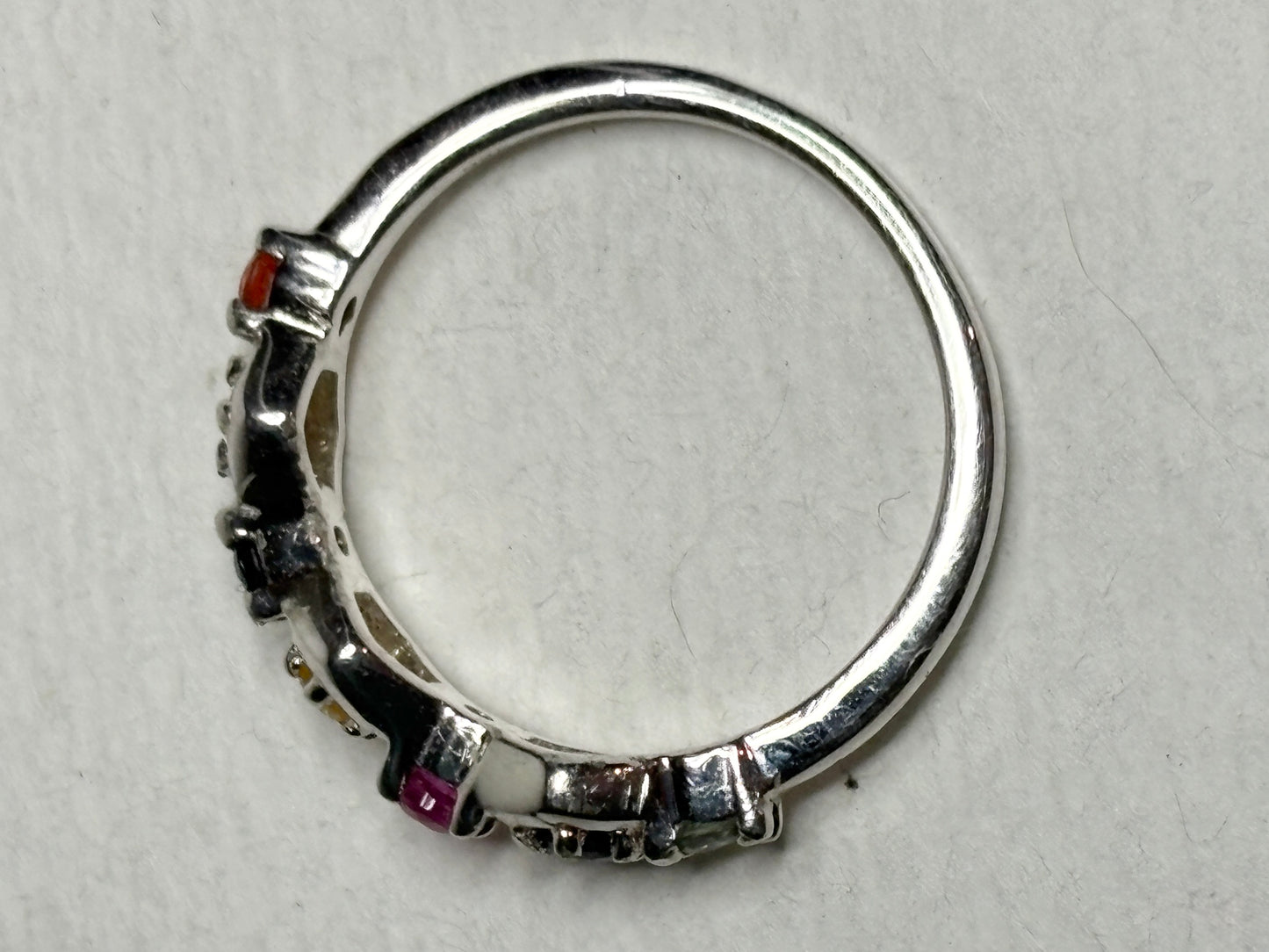 Sterling silver band ring with honeycomb shapes and multi-colored sapphires and a ruby.