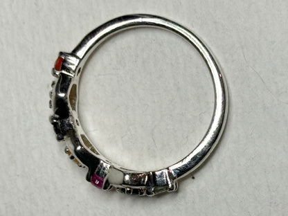 Sterling silver band ring with honeycomb shapes and multi-colored sapphires and a ruby.
