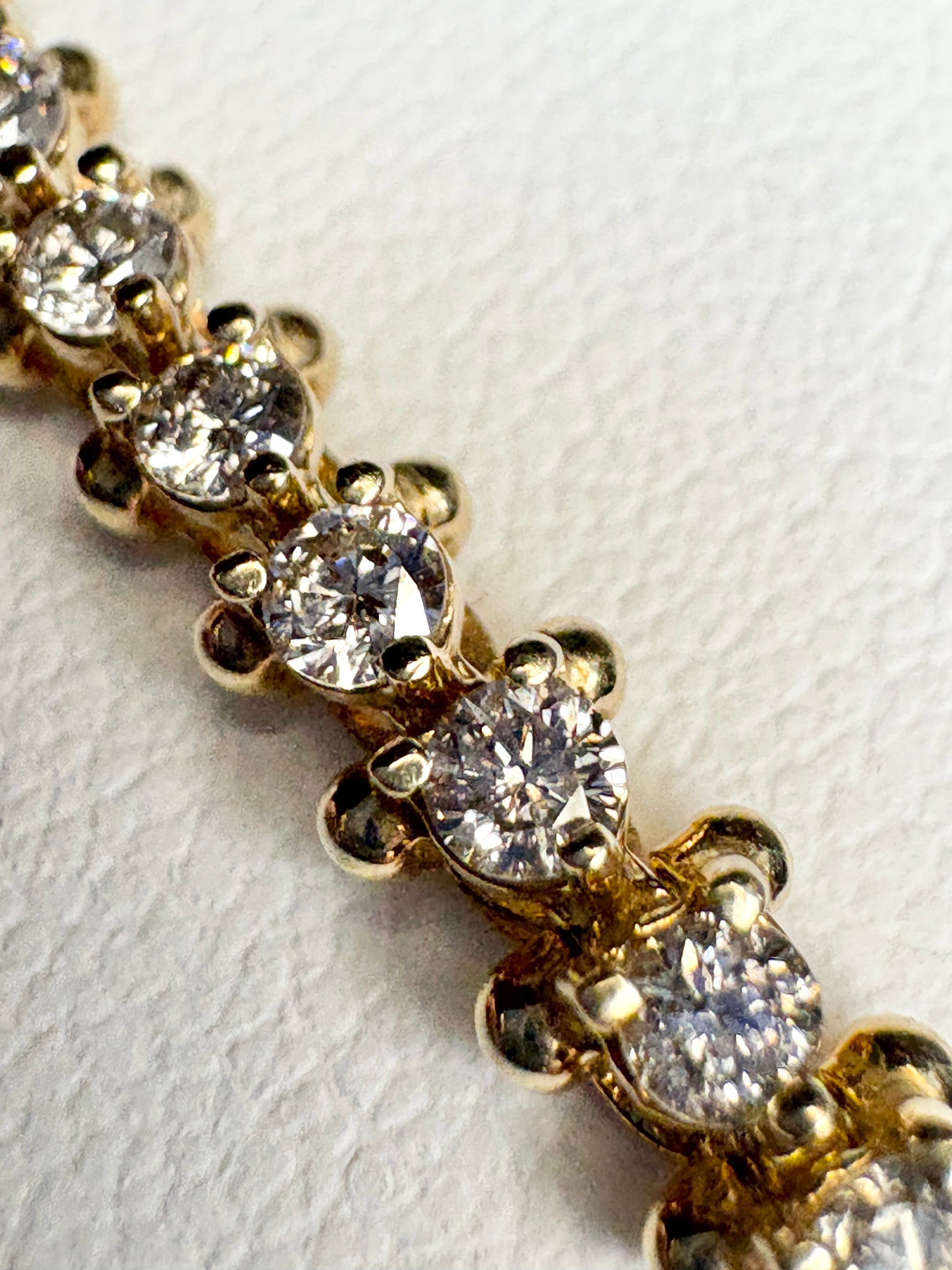 Diamond tennis bracelet with 57 round diamonds in solid 14k gold.