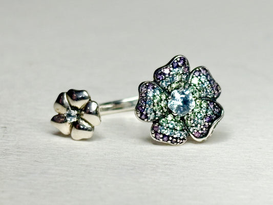 Sterling silver open ring with two floral charms featuring ombre colored pave set stones.