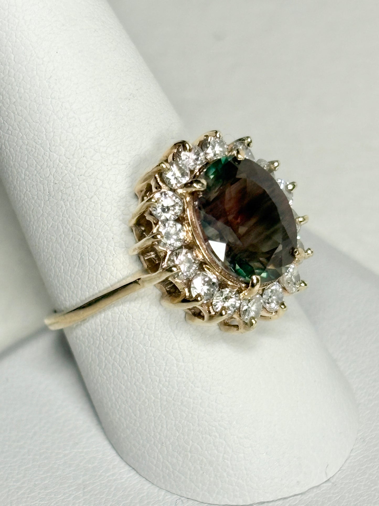 A 14k gold ring with a large dichroic Oregon sunstone and diamond halo.