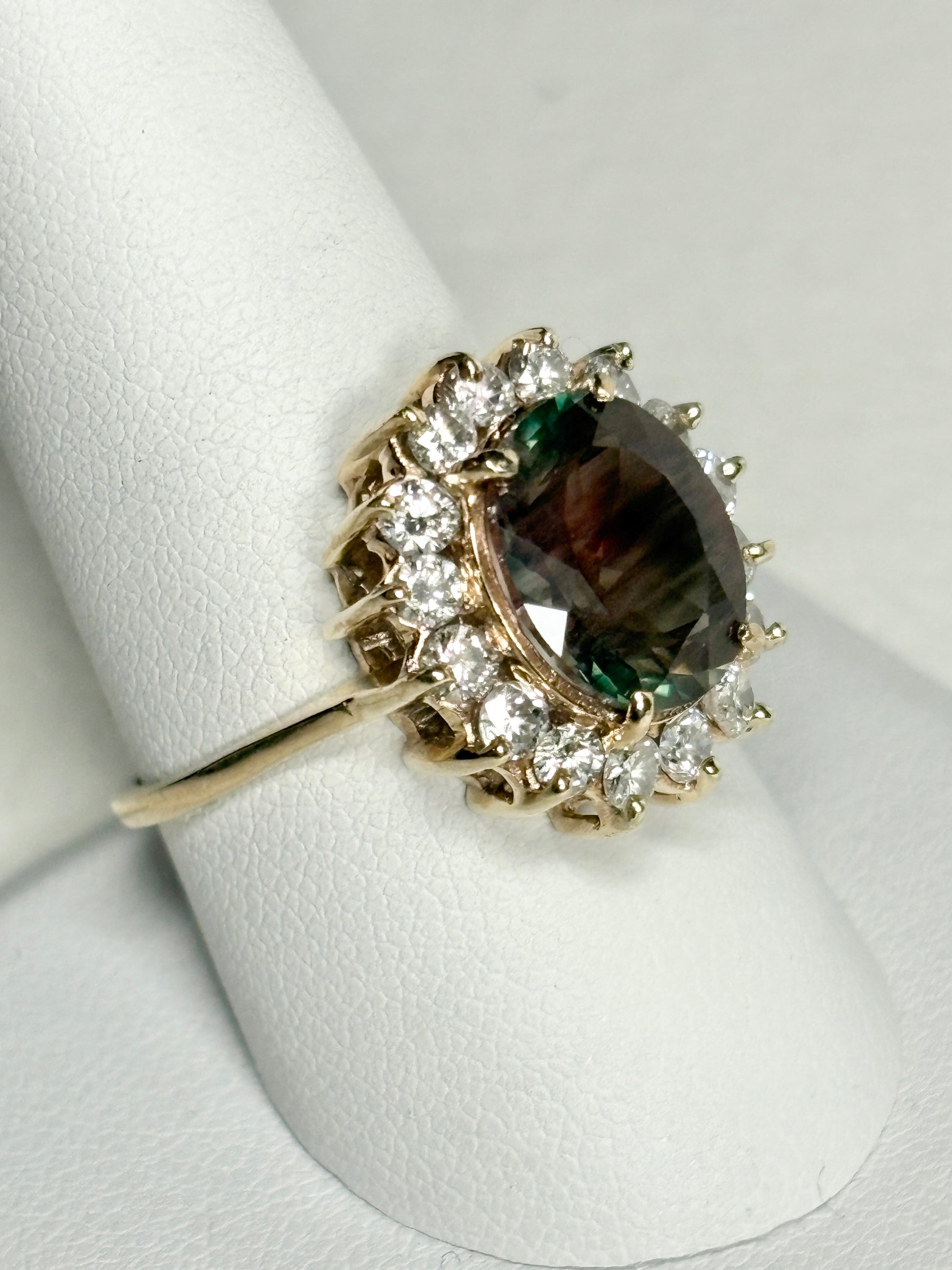 A 14k gold ring with a large dichroic Oregon sunstone and diamond halo.