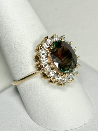 A 14k gold ring with a large dichroic Oregon sunstone and diamond halo.