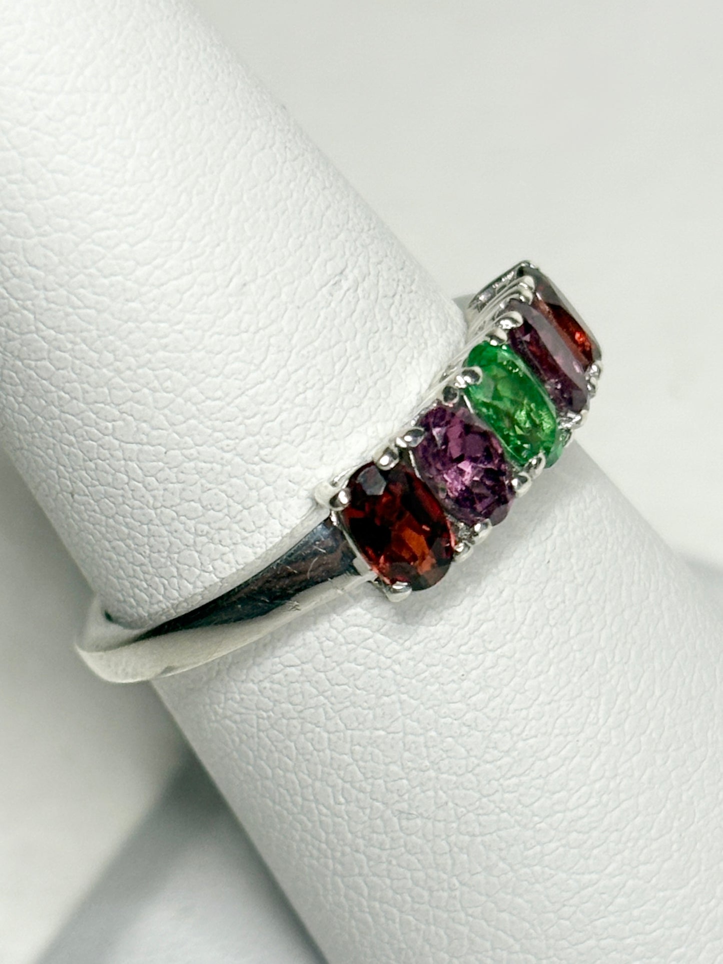 Sterling silver ring with five oval garnets in shades of red, purple, and green.